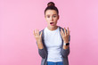 What do you want? Portrait of disgruntled teenage girl with bun hairstyle in casual clothes looking annoyed irritated with raised hands, asking why. indoor studio shot isolated on pink background