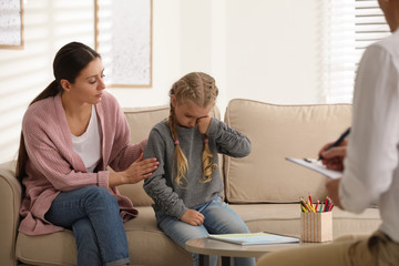 Sticker - Little girl and her mother on appointment with child psychotherapist indoors