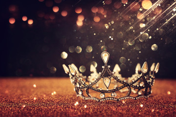 Poster - low key image of beautiful queen/king crown over gold glitter table. vintage filtered. fantasy medieval period
