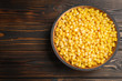 © New Africa - Delicious canned corn in bowl on wooden table, top view. Space for text