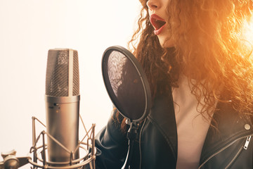 Wall Mural - Woman singing in music studio microphone