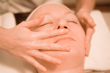 Beautiful plus size middle age woman getting a face massage treatment at beauty salon. close up step by step