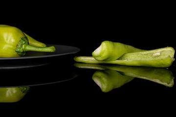 Wall Mural - Group of two whole two halves of hot green pepper banana on gray ceramic plate isolated on black glass