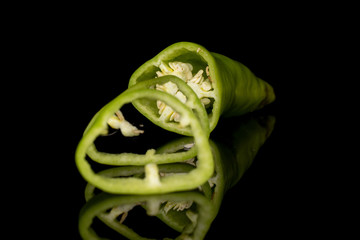 Wall Mural - Group of one half two slices of hot green pepper banana isolated on black glass