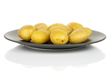 Wall Mural - Lot of whole pale yellow potato on gray ceramic plate isolated on white background