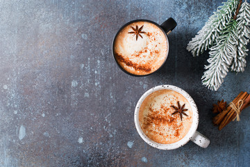 Two cups of coffee with crema, cinnamon and badian on dark background