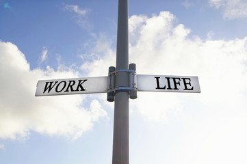 direction road sign with work and life words. Life balance choices signpost, with blue cloudy sky backgrounds