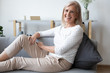 © fizkes - Laughing aged woman sitting on comfy couch resting feels happy