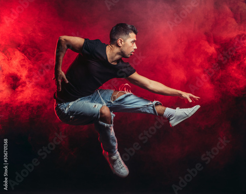 Photographie portrait of vigorous dancer male dancing street dance, jump in the air isolated