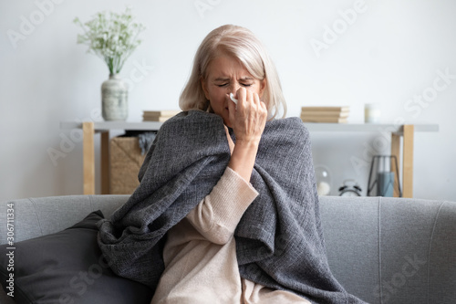 Fotografía Aged sick woman sneezing holding napkin blow out runny nose