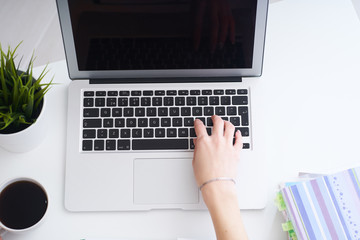 Business, education, people and technology concept - close up of female hands with laptop computer and coffee cup on table.