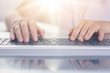 © sementsova321 - Woman typing on keyboard of PC on white background, female writing text on note book, man hands on keyboard, lap top on table, faceless portrait, programmer working online. Technology concept.
