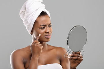 Wall Mural - Dissapointed black woman looking into the mirror after bath
