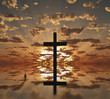 Man near giant cross with sunrise background