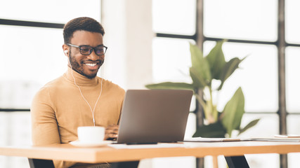 Smiling black student in glasses studying in bar