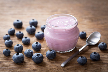 Wall Mural - glass jar of blueberry yogurt with fresh berries