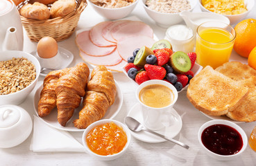 Wall Mural - Breakfast with croissants, coffee, juice, meat, jam, cereals and fresh fruits
