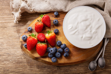 Wall Mural - bowl of yogurt with fresh berries on a wooden table