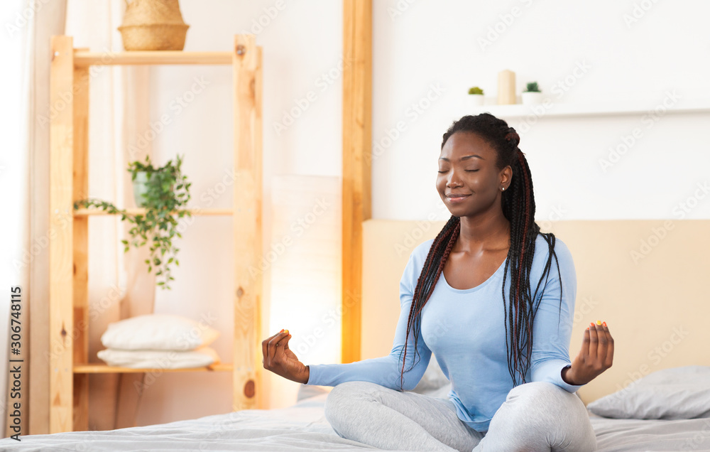 Peaceful Afro Lady Sitting Meditating In Bed At Home - obrazy, fototapety, plakaty 