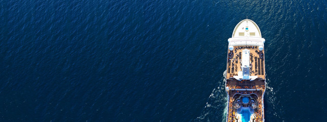 Aerial drone panoramic photo of huge cruise liner ship with top deck swimming pool cruising open ocean sea