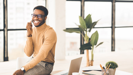 African man talking on cell phone at office