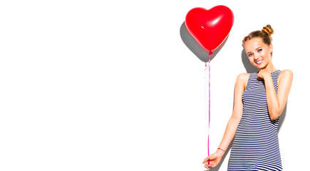 Wall Mural - Beauty girl with red heart shaped air balloon laughing over white background. Beautiful Happy woman on birthday party, Love, Valentine's Day party. Joyful model having fun, celebrating with balloons