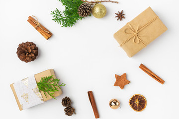 Wall Mural - Christmas New Years composition with gift boxes pine cones cinnamon dried oranges anise golden balls on white background. Holiday card poster template