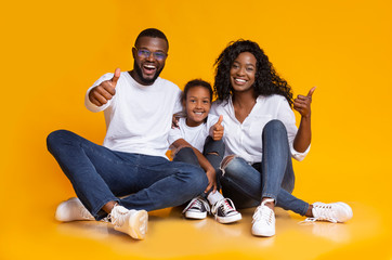 Portrait Of Joyful Black Family Gesturing Thumbs Up On Yellow Background