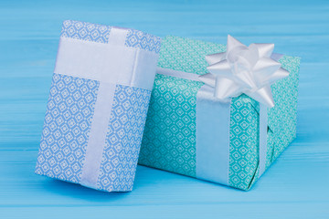 Two variety patterned gift boxes. Blue wooden table background.