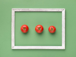 Wall Mural - Small cherry tomatoes inside eco wooden frame on light green