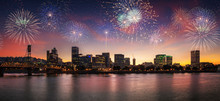 Flashing Fireworks On A Dramatic Sunset Sky With Portland, OR Cityscape With Willamette River And Hawthorne Bridge