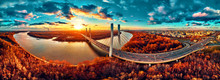 Beautiful Panoramic Aerial Drone View To Cable-stayed Siekierkowski Bridge Over The Vistula River And Warsaw City Skyscrapers, Poland In Gold Red Autumn Colors In November Evening At Sunset