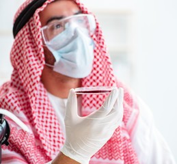 Wall Mural - Arab doctor chemist studying new virus in lab