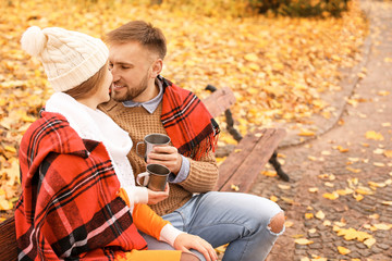 Poster - Loving young couple drinking hot tea in autumn park