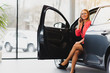 attractive businesswoman sitting in the car, talking on the phone and smiling