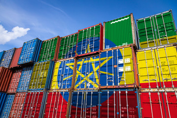 The national flag of Ethiopia. on a large number of metal containers for storing goods stacked in rows on top of each other. Conception of storage of goods by importers, exporters