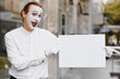 © Serhii - Your text here. Actor mime holding empty white letter. Colorful portrait with gray background. April fools day