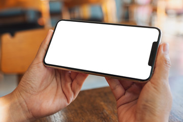 Mockup image of hands holding black mobile phone with blank desktop screen