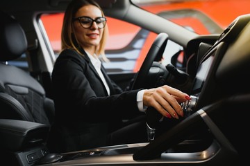 Wall Mural - Young business woman driving in her car to work. Successful business concept. business woman driving