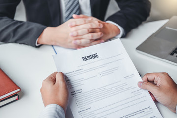 Wall Mural - Senior manager HR reading a resume during a job interview employee young man meeting Applicant and recruitment