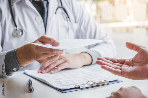 Fotografía Doctor or physician writing diagnosis and giving a medical prescription to male