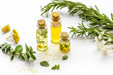 Aromatherapy. Essential Oils In Small Bottles Near Fresh Herbs On White Background