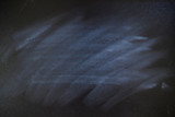 Fototapeta Kosmos - White chalk scratch on black board. Black board with messy scratch eraser white chalk. Abstract dirty background.