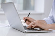© pressmaster - Hand of female employee pushing buttons of laptop keypad while sitting by desk