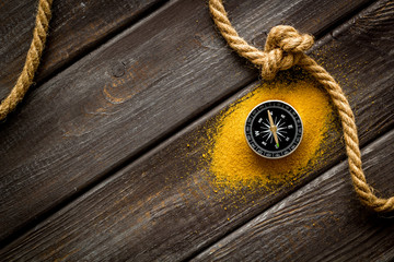 Wall Mural - Goal achievement concept. Compass near rope with knot on dar wooden background top view copy space