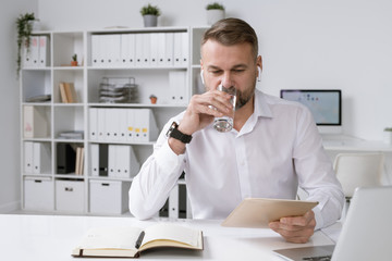 Aufkleber - Busy mature head of business company drinking water while using touchpad