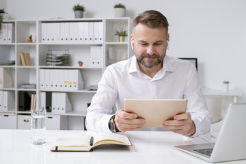 Aufkleber - Serious businessman with touchpad watching online video training or conference