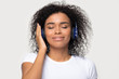 © fizkes - Calm peaceful African American woman in headphones enjoying music