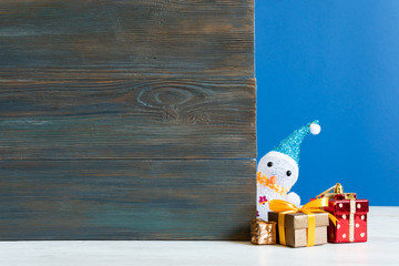 Wall Mural - Snowman in a snowdrift with gifts for Christmas and New year