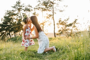 Stylish mother and handsome daughter having fun on the nature. Happy family concept. Beauty nature scene with family outdoor lifestyle. family resting together. Happiness in family life. Mothers day